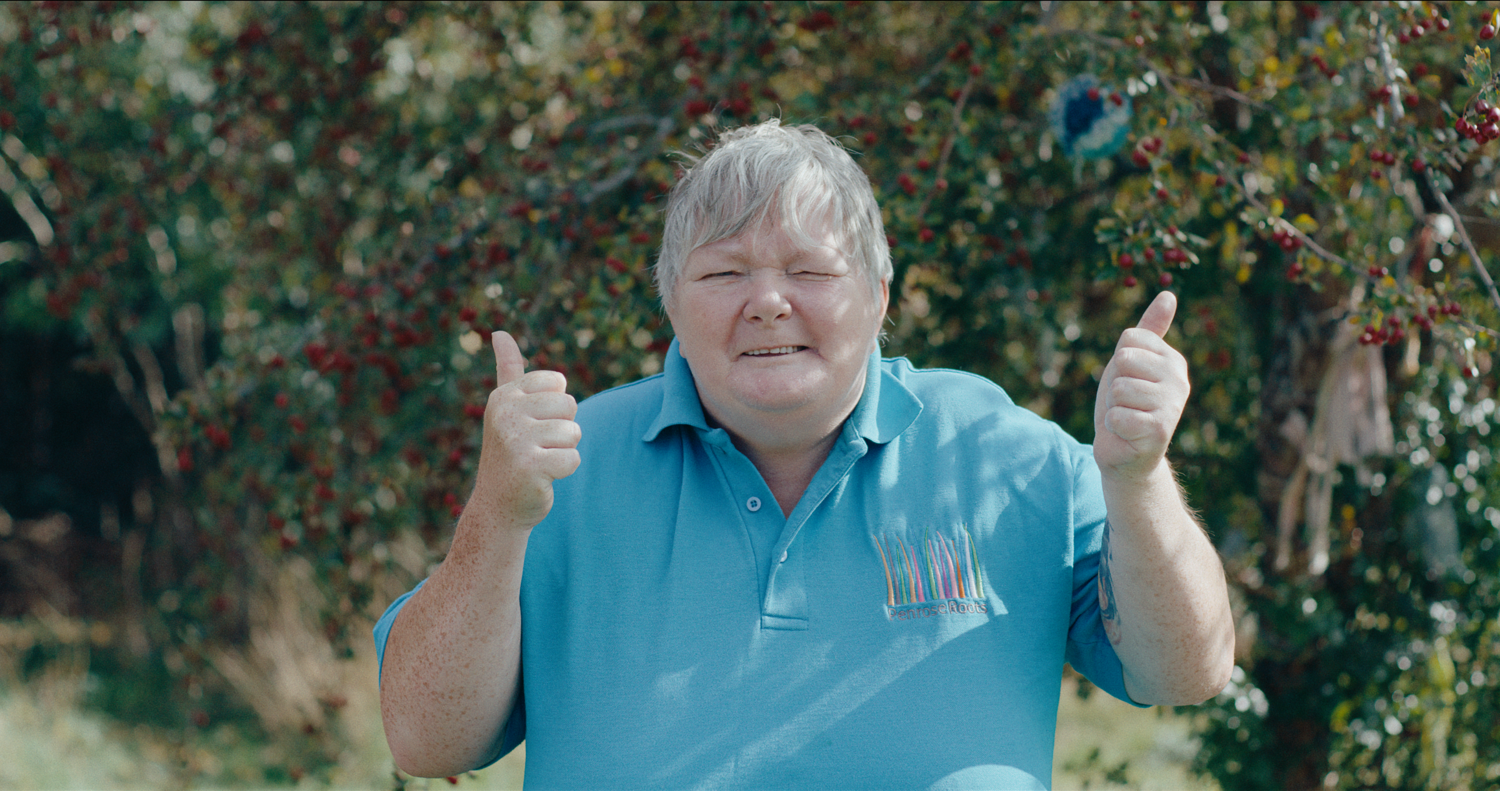 Volunteer giving two thumbs up outdoors
